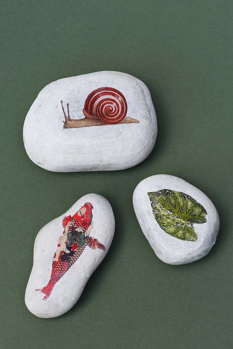 three image transferred stones on a green background