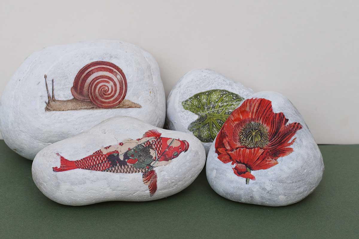 four rocks stones with printed vintage images on them