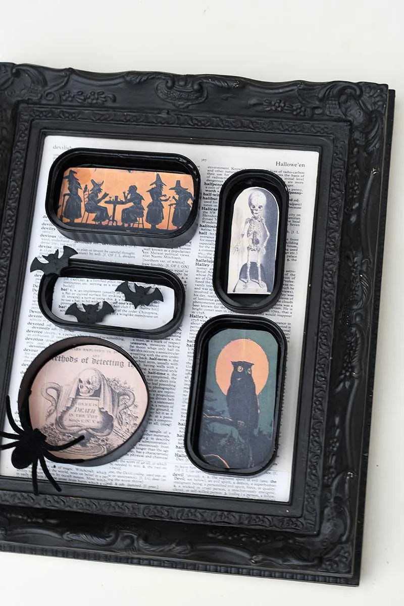 arranging the tin cans in the frame for DIY halloween shadow box